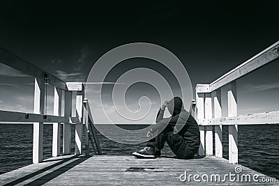 Alone Man at the Edge of Wooden Pier Stock Photo