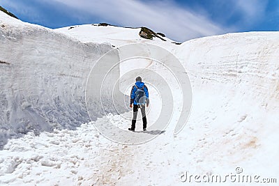 Alone man standing on snow walkway at Tateyama Kurobe Alpine Route Stock Photo