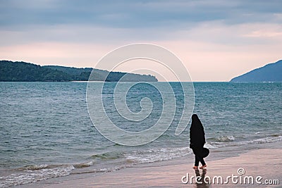 Alone Muslim Woman resting on the beach Stock Photo