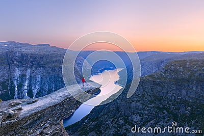 Alone tourist on Trolltunga rock - most spectacular and famous scenic cliff in Norway Stock Photo