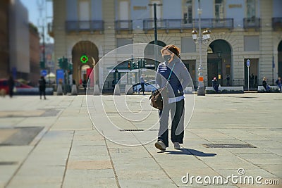 Alone woman strolling downtown wearing protective face mask Editorial Stock Photo