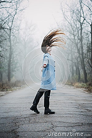 Alone Young woman with long fluttering hair express emotions in forest Stock Photo