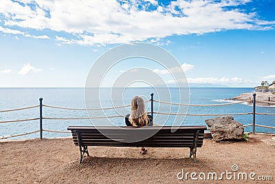 Alone young woman sitting on the bench Stock Photo