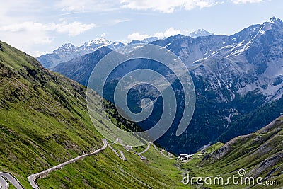 Alp road surrounded by blue alp high mountains. Steep descent of Passo dello Stelvio in Stelvio Natural Park Stock Photo