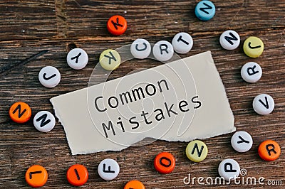 Alphabet beads and torn paper written with text COMMON MISTAKES Stock Photo