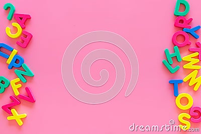 Alphabet for kids concept. English letters in disorder on pink background top view copy space Stock Photo