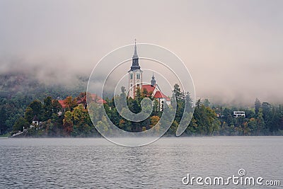 Alpine Bled lake (Blejsko jezero) in dense fog, amazing misty landscape, Slovenia, outdoor travel background Stock Photo