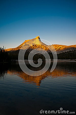 Alpine Glow on Cathedral Peak reflected in the lake Stock Photo