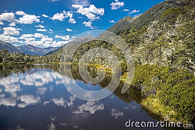 Alpine landscape with forest, lake, cloud reflection Stock Photo