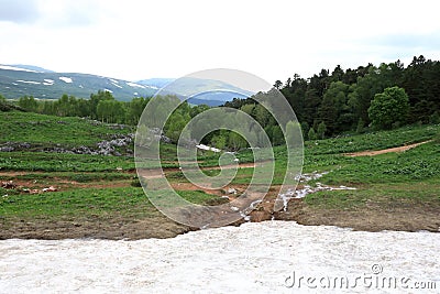 Alpine meadow and snowfield on the Lago-Naki plateau Stock Photo