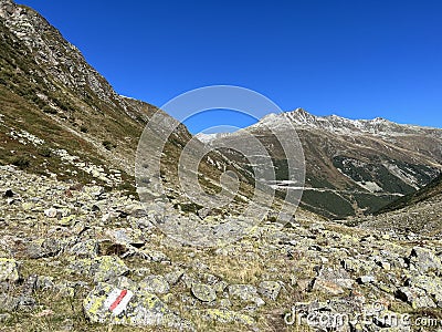 Alpine mountaineering signposts and markings in the mountainous area of the Albula Alps and above the mountain road pass Fluela Stock Photo