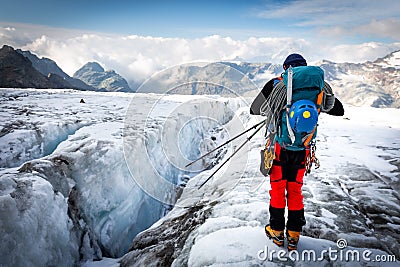 Alpinist standing glacier above crevasse mountains ridge view Stock Photo
