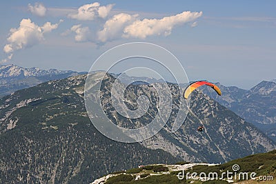 Alps. Dachstein Mountains. Austria. Paraplaner gliding in blue sky with view on Alpine mountains on paraplane Stock Photo
