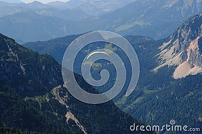 Alps. Dachstein Mountains. Austria. Paraplaner gliding in blue sky with view on Alpine mountains on paraplane Stock Photo