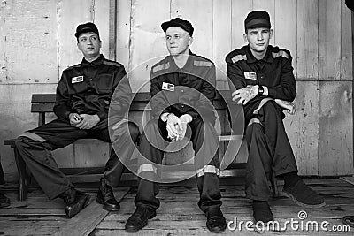 Prisoners play with a cat in the prison yard Editorial Stock Photo