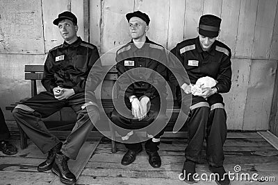 Prisoners play with a cat in the prison yard Editorial Stock Photo