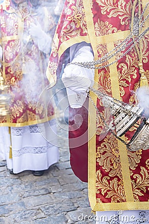 Altar boy or acolyte in the holy week procession shaking a censer to produce smoke and fragrance of incense Stock Photo