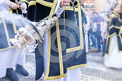 Altar boy or acolyte in the holy week procession shaking a censer to produce smoke and fragrance of incense Stock Photo