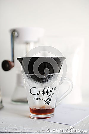 Alternative manual coffee brewing in porous ceramic paperless dripper filter. Manual coffee grinder on background Stock Photo