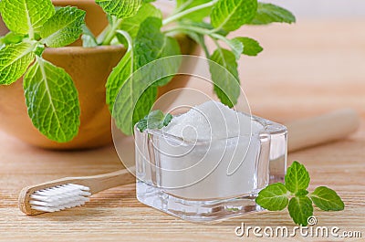 Alternative natural toothpaste xylitol, soda, salt, and wood toothbrush closeup, mint on wooden Stock Photo