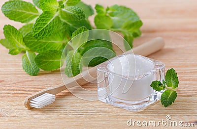 Alternative natural toothpaste xylitol, soda, salt, and wood toothbrush, mint on wooden Stock Photo