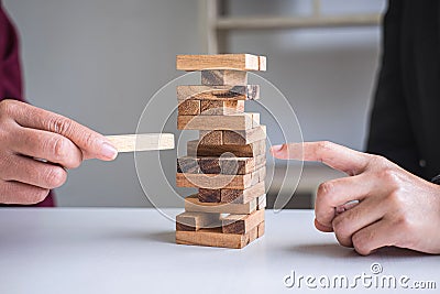 Alternative Risk and Strategy in Business, Hand of business team cooperative gambling placing making wooden block hierarchy on the Stock Photo