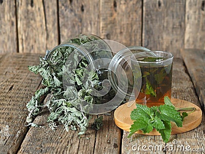 Alternative traditional medicine.Dried leaves of Melissa or mint with a fresh twig and decoction in a glass on an ancient wooden Stock Photo