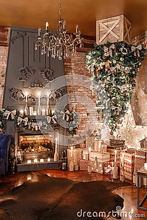 Alternative tree upside down on the ceiling. Winter home decor. Modern loft interior with fireplace and brick wall Stock Photo