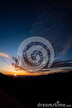 Altus cumulus cirrus clouds on a dark blue sunrise sky landscape Stock Photo