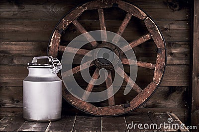 Aluminium water can and old wheel Stock Photo