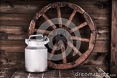 Aluminium water can and old wheel Stock Photo
