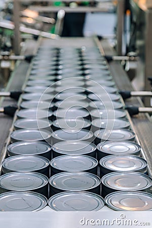 Aluminum cans for food processed in factory line conveyor machine at canned food manufacturing, selective focus Stock Photo