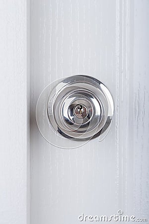 Aluminum door knob on white door Stock Photo