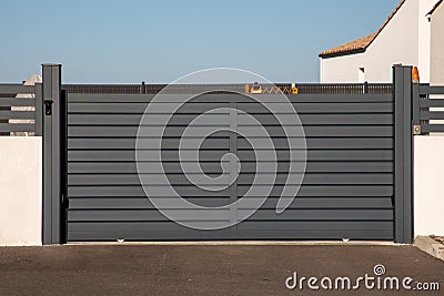 Aluminum portal sliding grey large car gate of modern house in street view Stock Photo