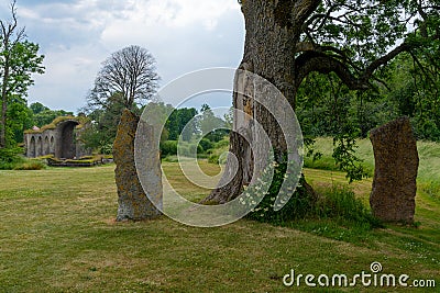 Large obelisk boulders with the ruins of the Alvastra Abbey in the background Editorial Stock Photo