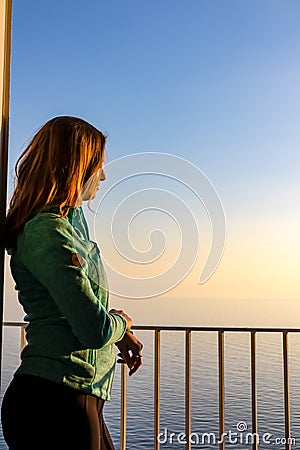 Amalfi - Woman enjoying a warm sunset at the Amalfi Coast in Italy from her hotel window Stock Photo