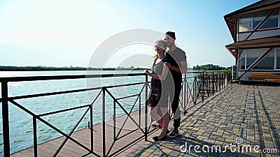 Amants se tenant ensemble sur le quai en pierre près de leur maison de lac, jeune couple romantique ensemble banque de vidéos Amants se tenant ensemble sur le quai en pierre près de leur maison de lac, jeune couple romantique ensemble banque de vidéos