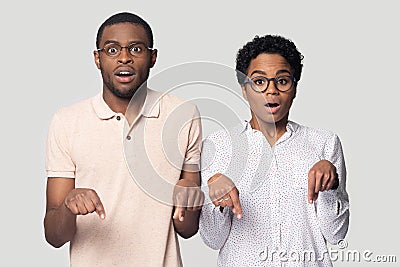 Amazed african American couple point down showing sale offer Stock Photo