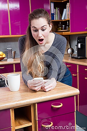 Amazed beautiful young woman connected to the internet from home Stock Photo