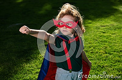 Amazed child superhero hero in red cloak in nature. Stock Photo