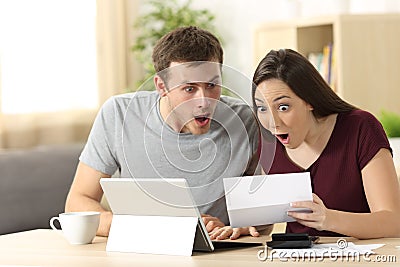 Amazed couple reading together a letter Stock Photo