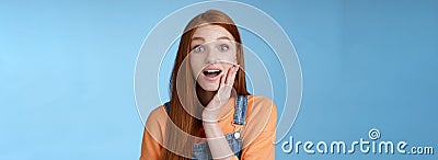 Amazed friendly sensitive impressed redhead girl learn awesome pleasant news open mouth wondered astonished smiling glad Stock Photo