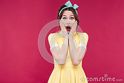 Amazed pinup girl in yellow dress standing with mouth opened Stock Photo