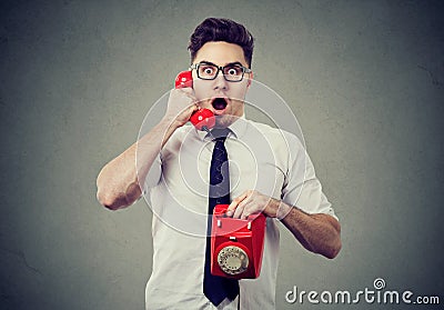 Amazed shocked man talking on a telephone Stock Photo