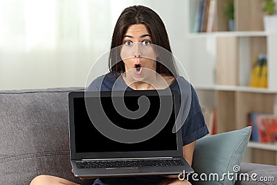 Amazed teen showing you a blank laptop screen Stock Photo