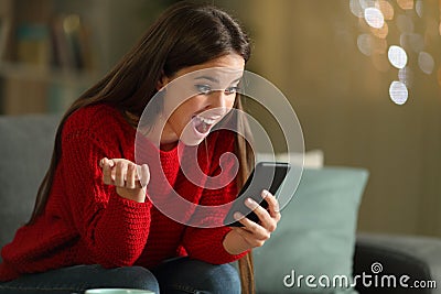 Amazed woman reading news on phone in the night Stock Photo