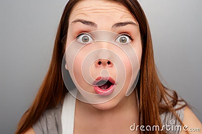 Amazed young woman over grey background Stock Photo