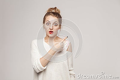 Amazement blonde woman pointing finger at copy space Stock Photo