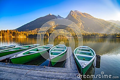 Amazing autumn scenery on Hintersee lake with boats moored on wooden pier, Bavaria, Germany Stock Photo