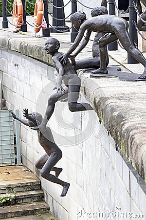 Amazing bronze statues by Chong Fah Cheong of children jumping into the Singapore River Editorial Stock Photo
